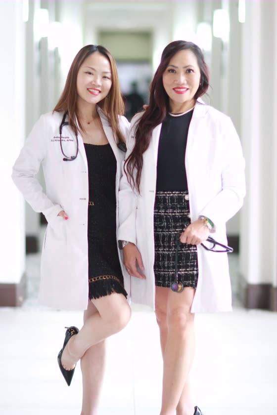 Dr. Li Kruszka and Dr. Winnie Wong standing together in white coats in the clinic corridor.
